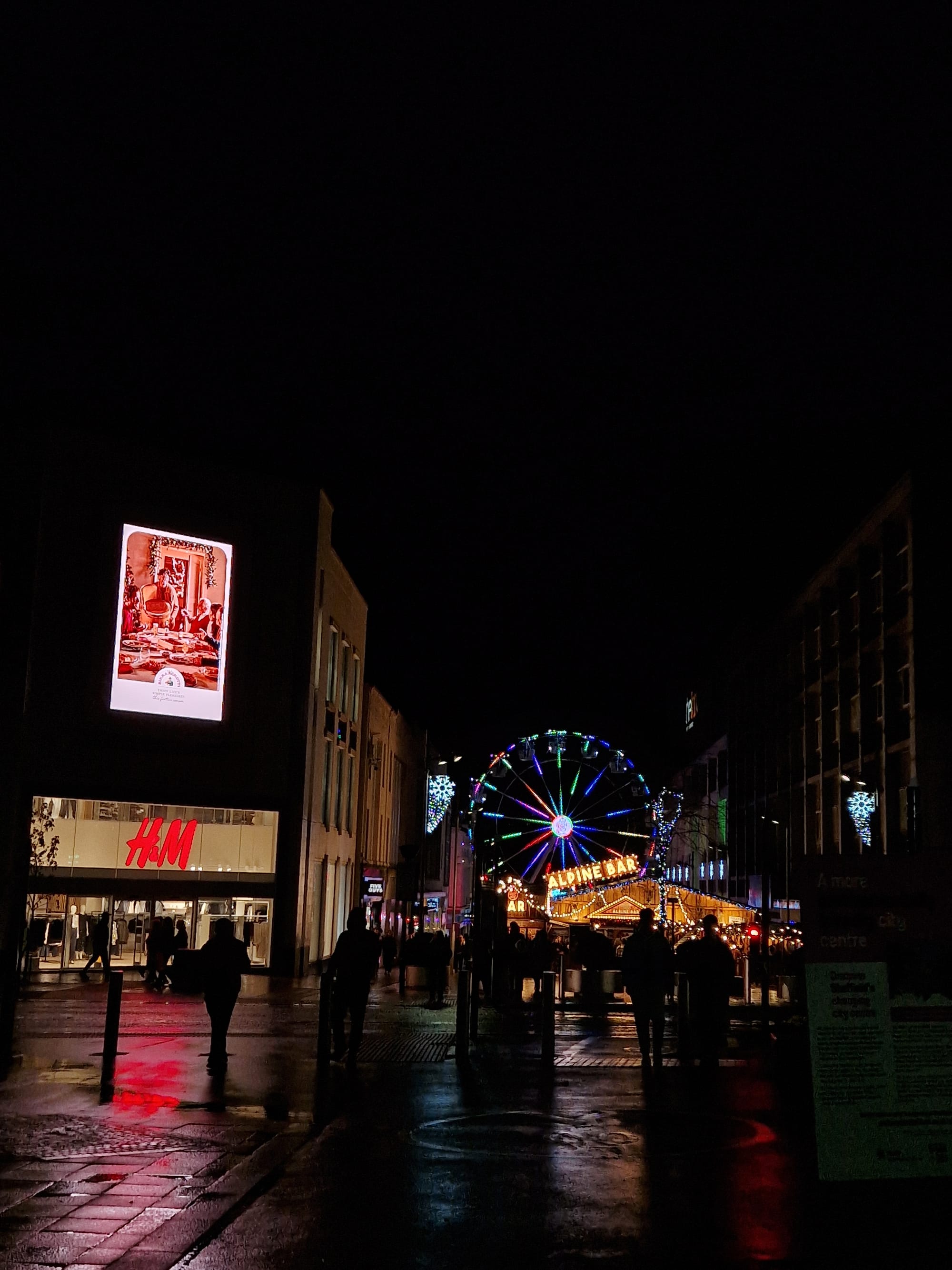 Christmas lights reflect in the darkness of Sheffield.